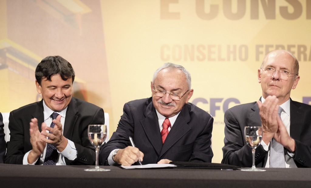 José Martonio Alves Coelho assina o Termo de Posse. À esquerda, o governador do Piauí, Wellington Dias; e, à direita, o senador Paulo Bauer